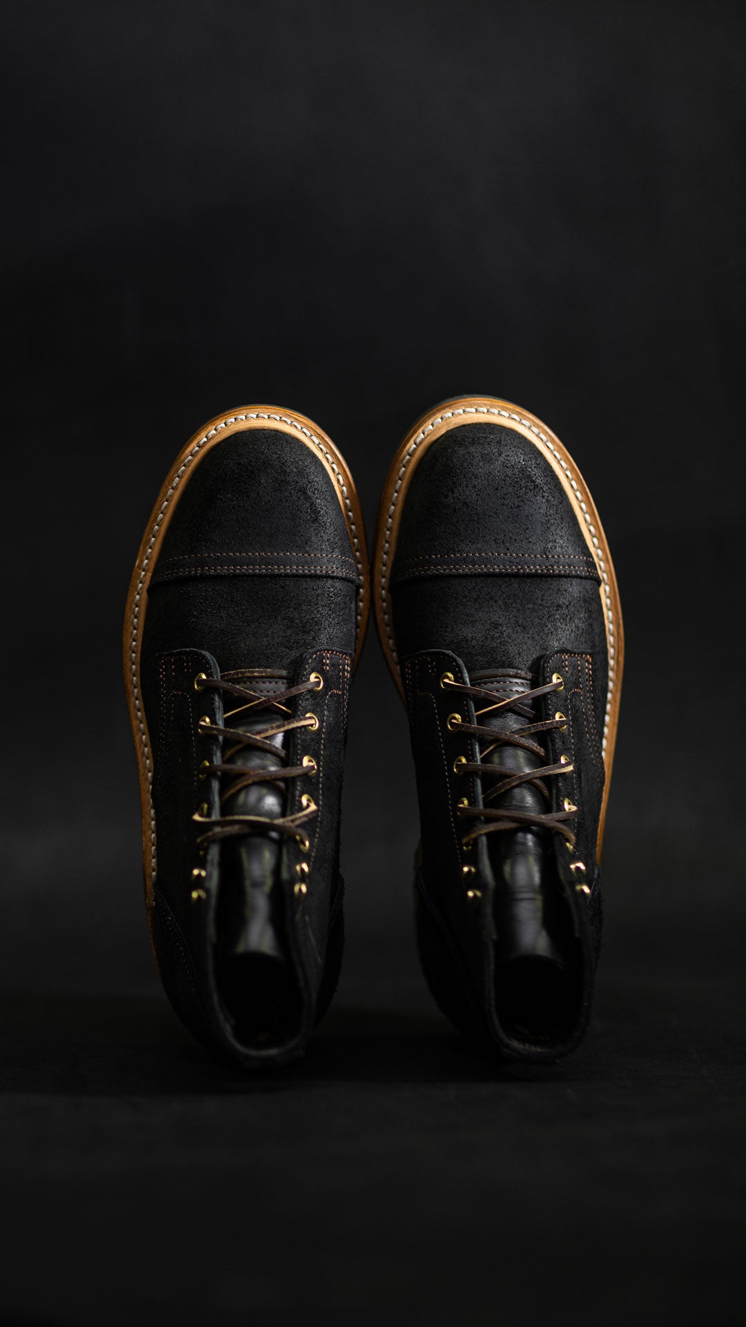 pair of truman boots in black oiled rough out leather against dark background